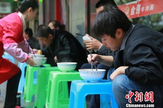 10月31日早，蘭州市永昌路一家牛肉面館門庭若市,，20多平米的面館坐得滿滿當當,，面館門外，顧客們有蹲著吃的,，也有放個小板凳擱著吃的,，取面口排成10余米的長隊。 劉玉桃 攝