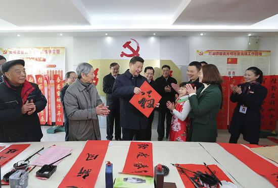 2016年2月3日,,習(xí)近平在南昌市東湖區(qū)彭家橋街道光明社區(qū)書畫室,,接過一位小朋友現(xiàn)場(chǎng)書寫的 “福”字,,祝大家都幸福,。新華社記者 蘭紅光 攝